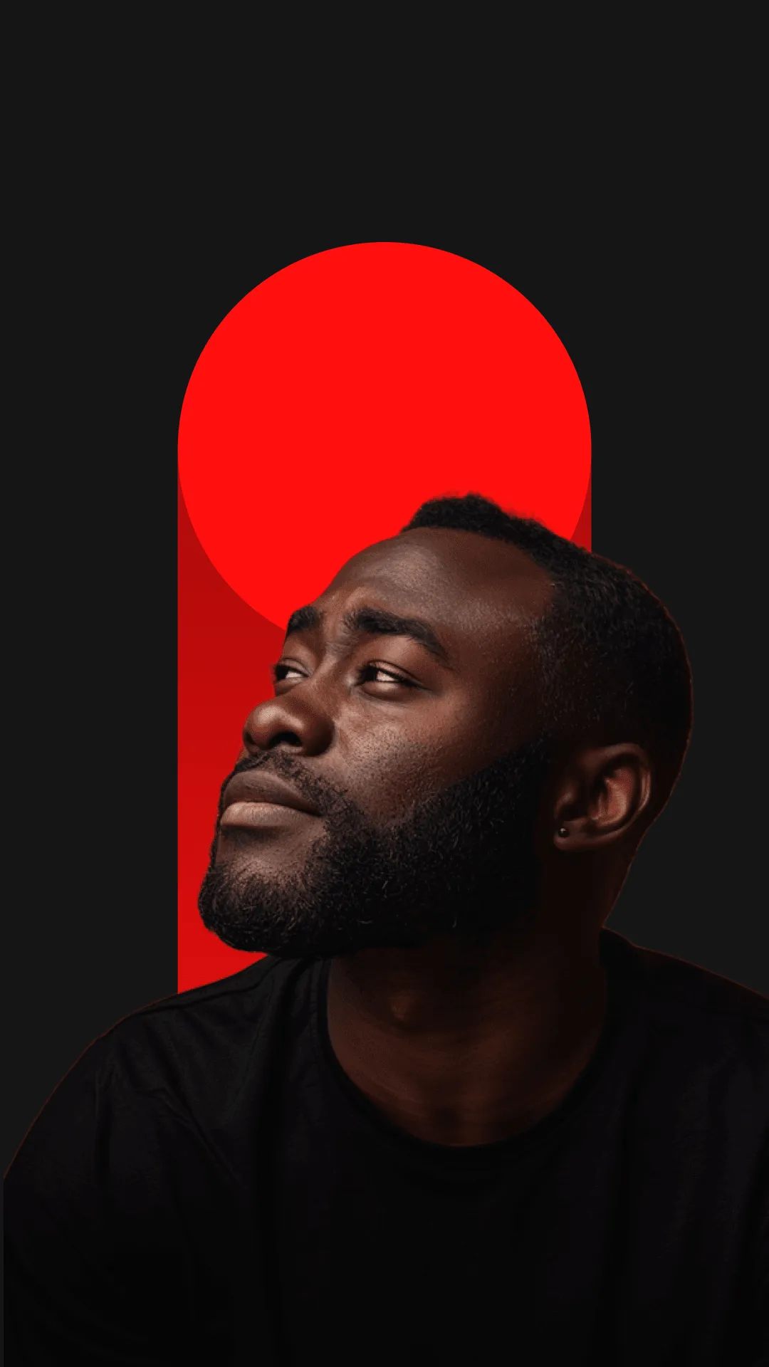 Portrait of a Black man with a beard looking up to the left, wearing a black shirt against a dark background with a bold red circle and vertical rectangle behind him.
