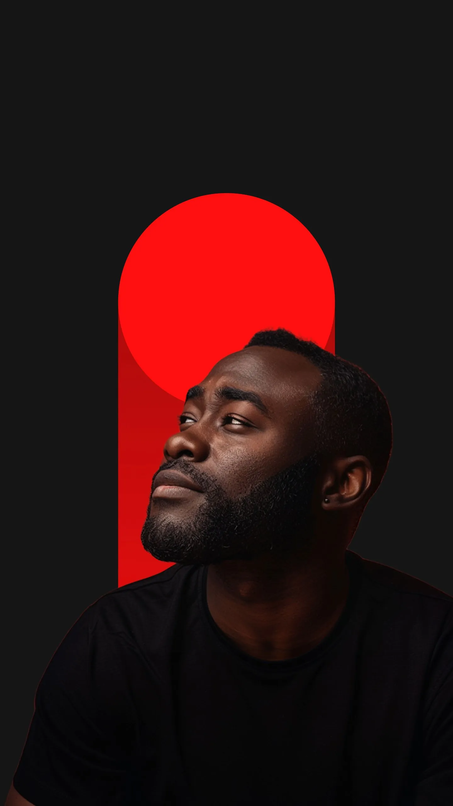 Portrait of a Black man with a beard looking up to the left, wearing a black shirt against a dark background with a bold red circle and vertical rectangle behind him.