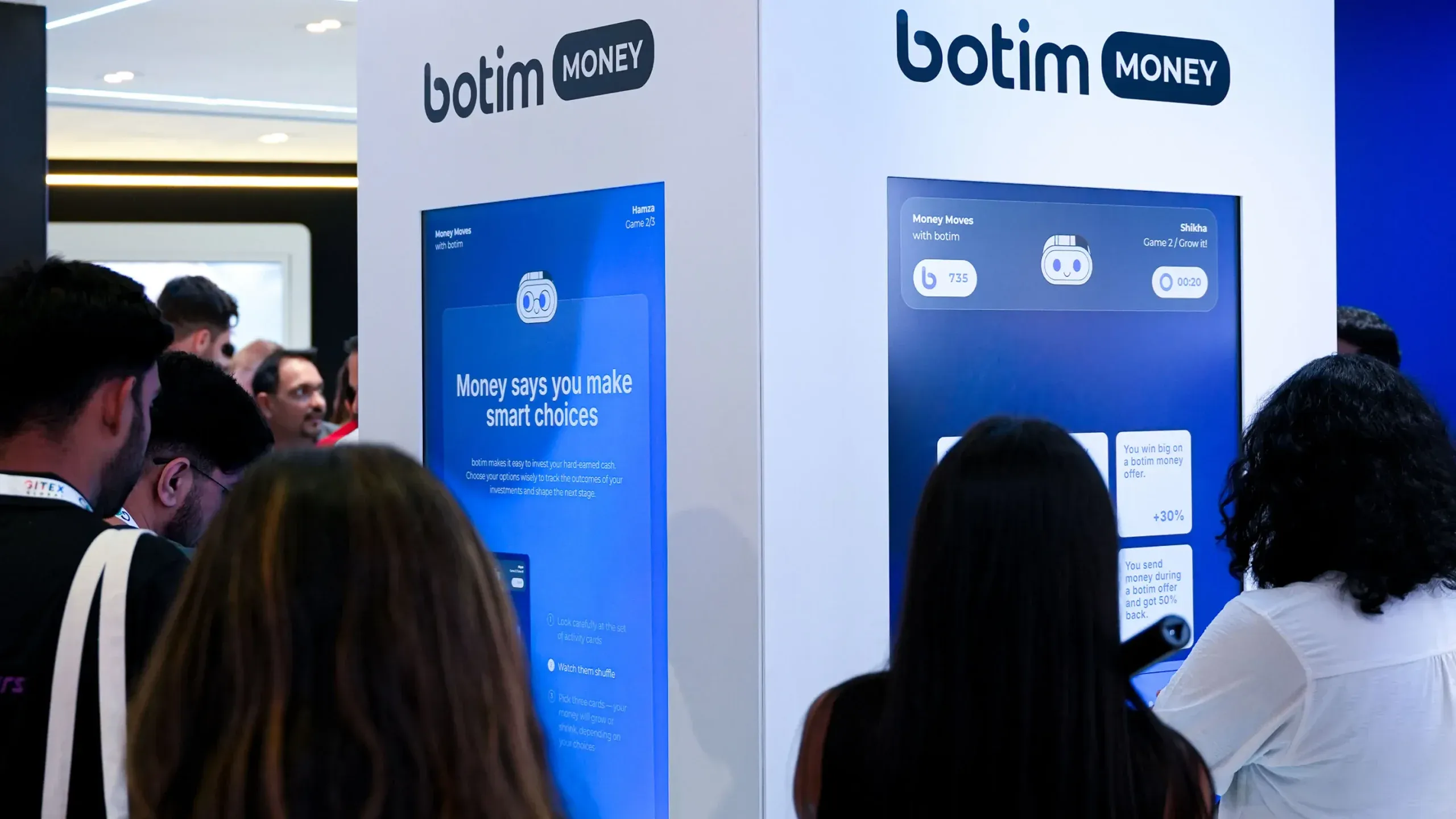A crowd watches and waits to play Money Moves at the botim booth.
