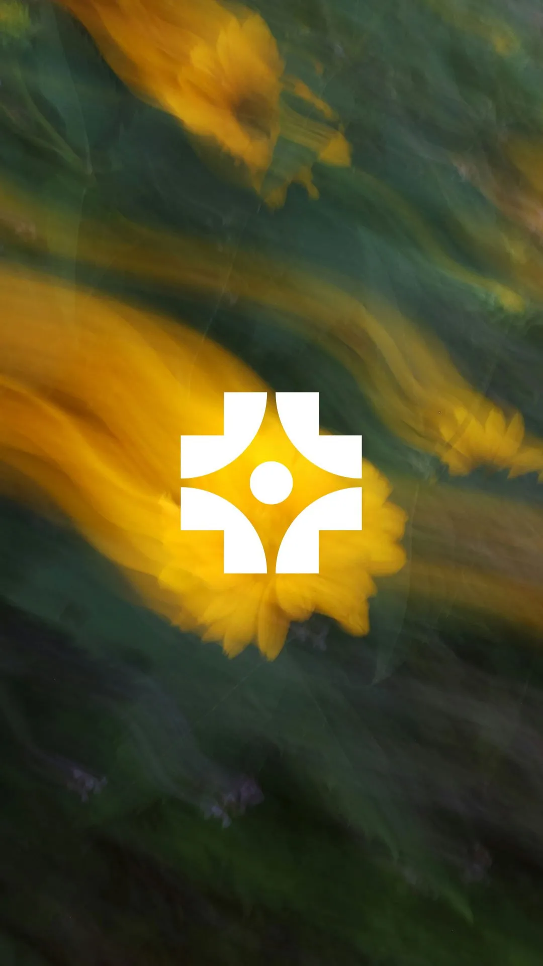 White geometric cross logo with a center circle over blurred yellow flower petals and green foliage